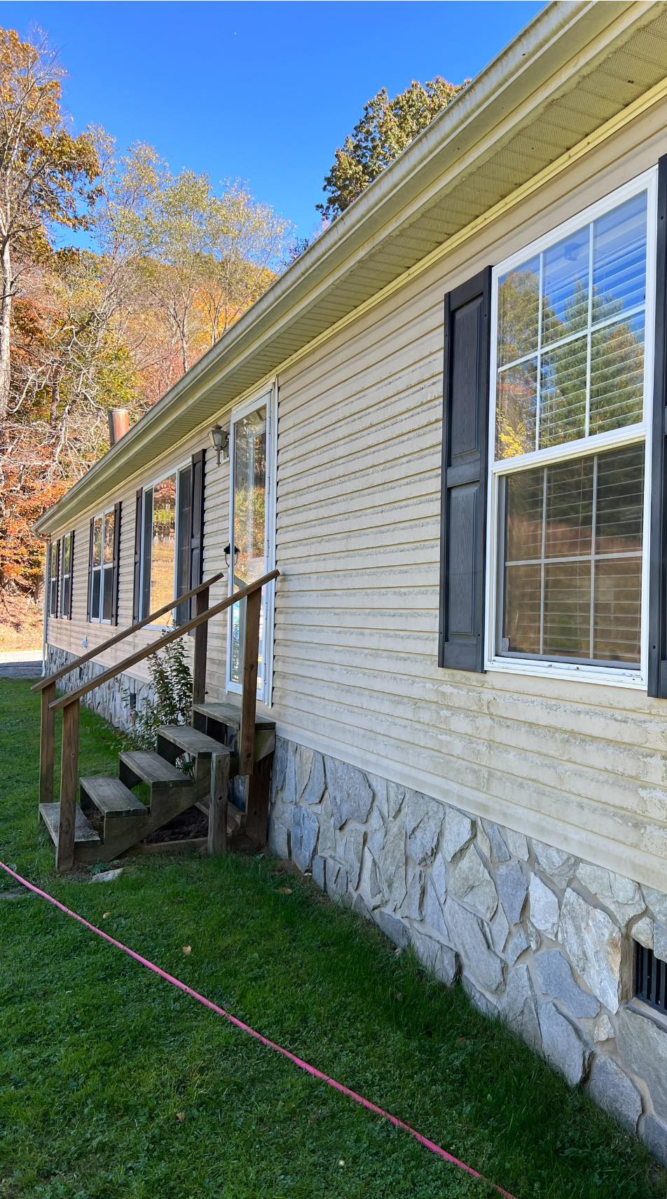 Home siding before cleaning, showing dirt, grime, and mildew.