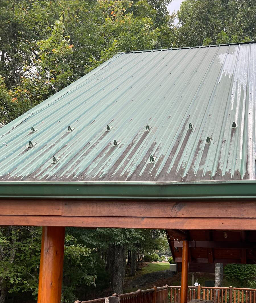 A faded metal roof with dirt and stains.